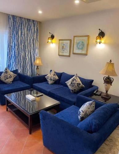 a living room with blue couches and a coffee table at Porto Marina Patio Suite - Egyptian Residents Only in El Alamein