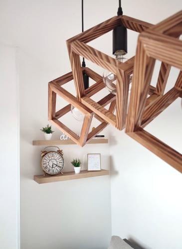 a wooden chandelier hanging from a wall with shelves at Apartman NS Dan PRIVATE PARKING in Novi Sad