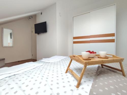 a room with a table with two bowls of fruit on it at Apartman NS Dan FREE PARKING in Novi Sad