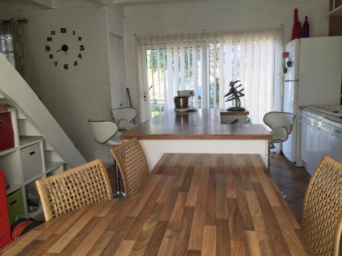 une cuisine avec une table et des chaises dans une pièce dans l'établissement Maison avec piscine Labenne Océan, à Labenne