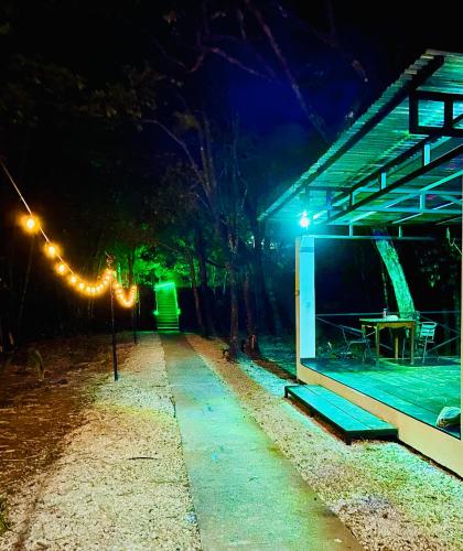 a building with a table and lights at night at Antema Lodge Secteur Tamarindo, piscine, yoga, gym, jungle et paix in Tamarindo
