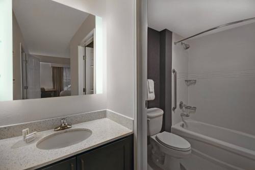 a bathroom with a sink and a toilet and a mirror at Residence Inn Louisville Airport in Louisville