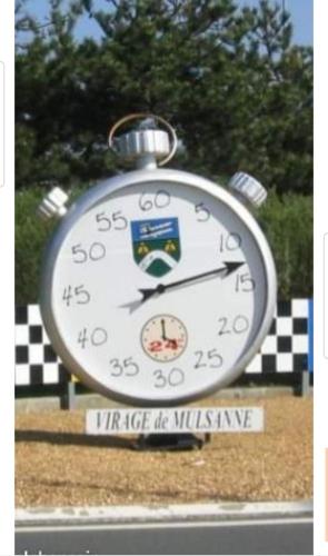 eine Uhr, die auf dem Rasen auf einem Feld sitzt in der Unterkunft Chambre proche circuit 500 m du virage de Mulsanne in Mulsanne
