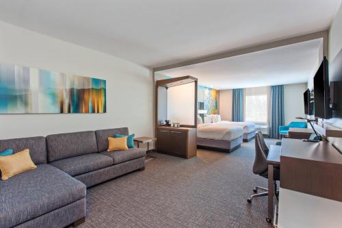 Courtyard by Marriott San Diego El Cajon في إل كاجون: غرفة في الفندق مع أريكة وسرير