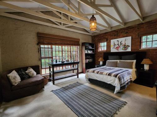 a bedroom with a bed and a chair and a couch at 8 at Norman Crescent in Johannesburg