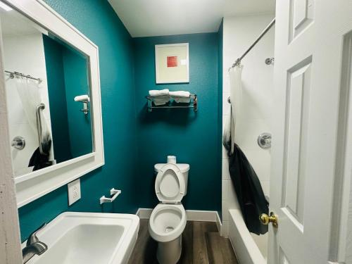 a bathroom with a toilet and a sink and a mirror at Casa Blanca Inn - Whittier, Los Angeles in Whittier
