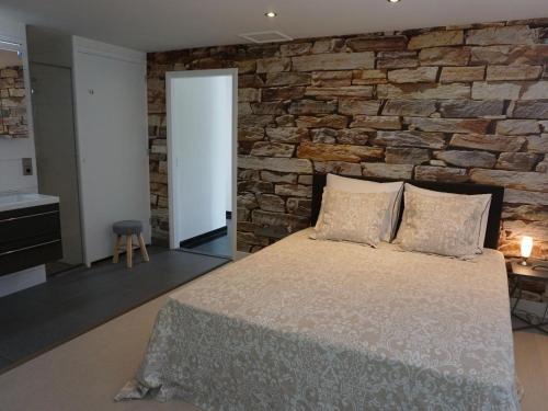 - une chambre avec un mur en pierre et un lit dans l'établissement Bungalow perfect for water sports, à Kamperland