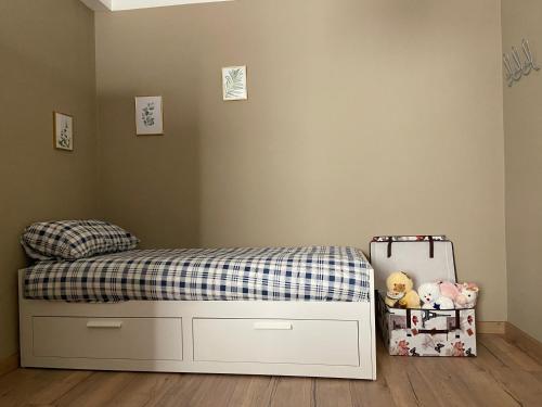 a bedroom with a bed with a checkered blanket and a suitcase at Casa di Lucy Umbria in Foligno