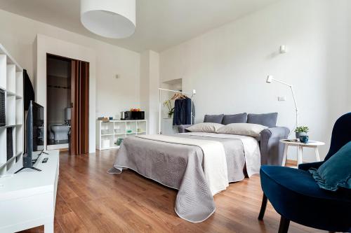 a white bedroom with a bed and a tv at A central quiet sunny studio in Verbania in Verbania