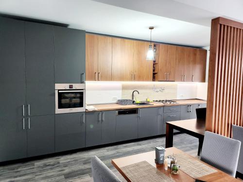a kitchen with gray cabinets and a table and a tableablish at Armina's Residence Villa in Dumbrăviţa