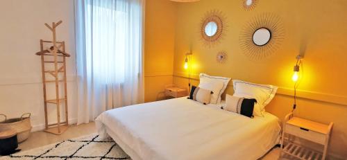a bedroom with a large white bed with yellow walls at Coeur du centre ville, haut prestation climatisation et Parking gratuit in Troyes