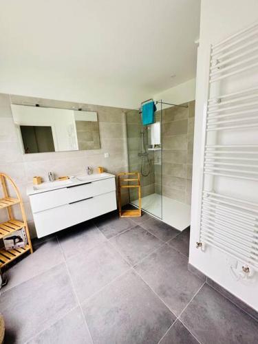 une salle de bain avec un lavabo et une douche dans l'établissement Maison d’architecte - plages, à Larmor-Plage