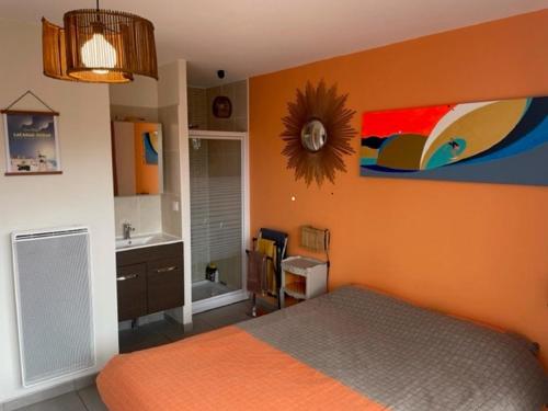 een oranje slaapkamer met een bed en een wastafel bij "Les 2 Pins" Villas 4 chambres 10-12 couchages in Lacanau