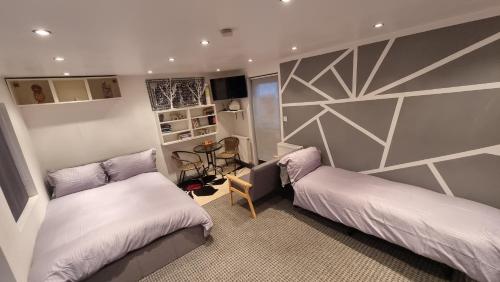 a small bedroom with two beds and a table at Rear of Levett Gardens in Seven Kings