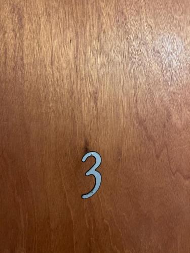Een bruine deur met een nummer drie erop. bij Shaligohomes @ 4425 E 6th Ave in Anchorage