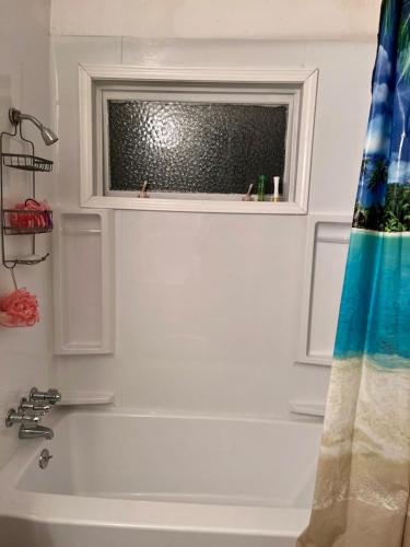een badkamer met een bad en een raam bij Shaligohomes @ 4425 E 6th Ave in Anchorage