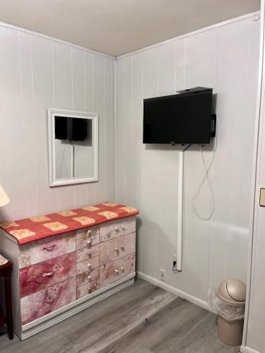 a room with a tv on a wall with a dresser at Shaligohomes @ 4425 E 6th Ave in Anchorage