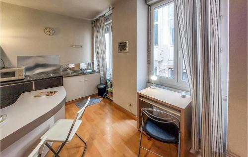 małą kuchnię z biurkiem i stołem z krzesłami w obiekcie 1 Bedroom Lovely Apartment In Saint-etienne w mieście Saint-Étienne