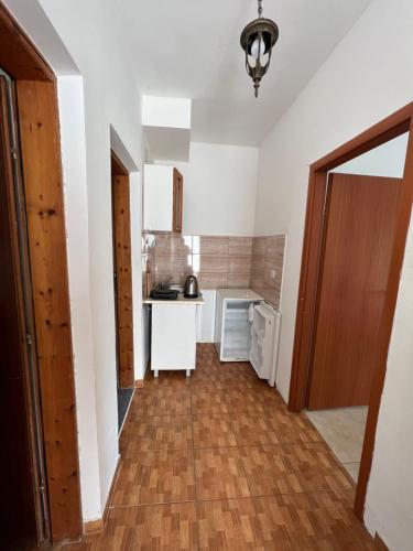a kitchen with white walls and a wooden floor at Green Villa in Bar, Susanj