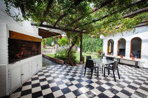 a patio with a table and a fireplace at Posada de Rosas in Mendoza
