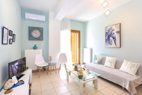 una sala de estar con un sofá y una mesa en Cozy central apartment a few steps from the beach, en Hersonissos