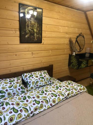 Un dormitorio con una cama y un cuadro en la pared. en Forest hugs котедж Славсько, en Khashchovanoye