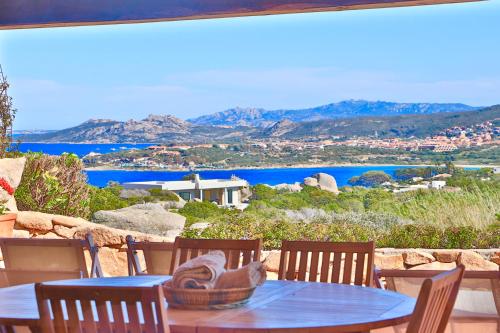 a table and chairs with a view of the water at Cottage Sardinia by KlabHouse in Palau