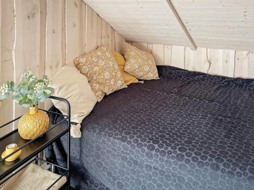 a bed in a small room with pillows on it at Holiday home Sydals XL in Neder Lysabild