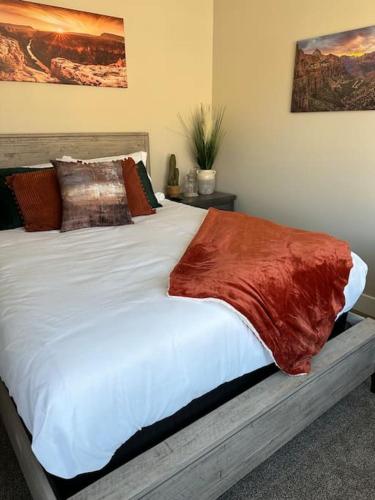 a large white bed with a red blanket on it at Grand Canyon-4bed,3bath,hot tub in Hildale