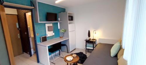 a small living room with a couch and a desk at MICHELET Studio climatisé avec balcon et parking ferme in Montpellier