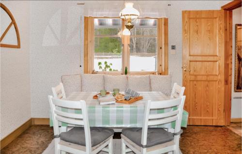 a dining room with a table and chairs and a window at Awesome Home In Åmål With Wifi in Åmål