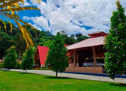 a building with a red roof with a car parked in it at Cabañas Amalú in San Agustín