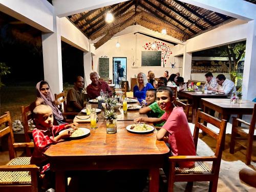 a group of people sitting at a table in a restaurant at 108 Palms Beach Resort in Trincomalee