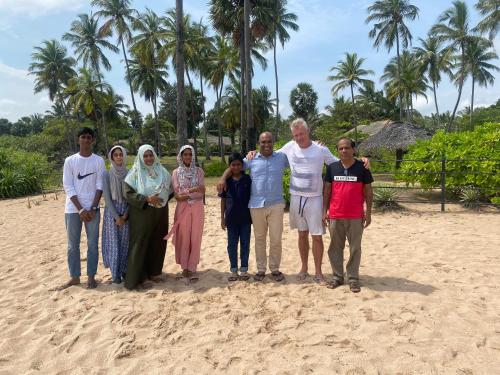 a group of people posing for a picture on the beach at 108 Palms Beach Resort in Trincomalee