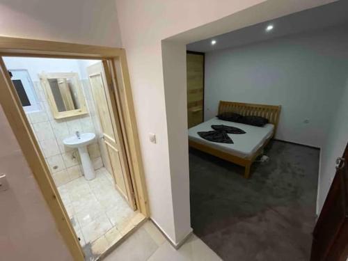 a bedroom with a bed and a bathroom with a sink at Vienna Montenegro Lleshi in Donji Štoj
