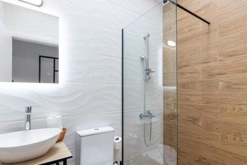 a bathroom with a sink and a glass shower at Pagani Blue - Luxury Maisonette B3 in Kalamata