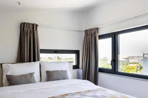 a bedroom with a bed and a large window at Pagani Blue - Luxury Maisonette B3 in Kalamata