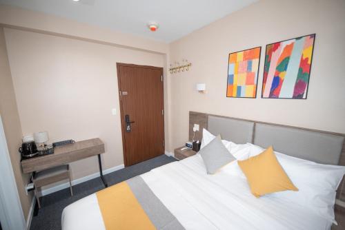 a hotel room with a bed and a desk and a bed sidx sidx sidx at Flushing Garden Hotel in Queens