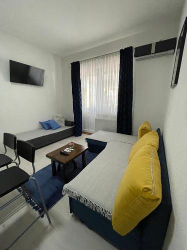 a room with a bed and a table and a couch at Guest House Mylan in Ličko Petrovo Selo