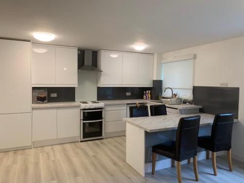 a kitchen with white cabinets and a table and chairs at Nature in London