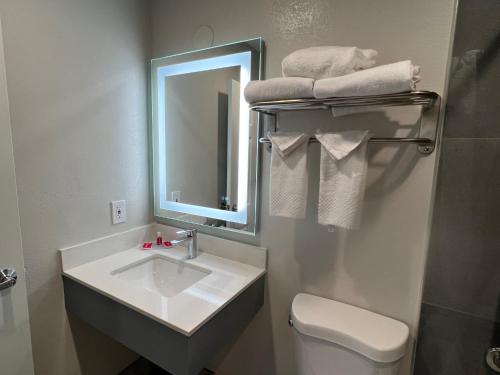 a bathroom with a sink and a mirror and a toilet at Quality Inn Tracy I-205 in Tracy