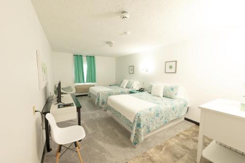 ein Hotelzimmer mit 2 Betten und einem Schreibtisch in der Unterkunft EC Reed's Mercantile and Hotel in Marble Hill