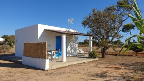 una pequeña casa blanca con una mesa delante en CASA PATY, Estudio rural. Sant Ferran FORMENTERA, en Sant Ferran de Ses Roques