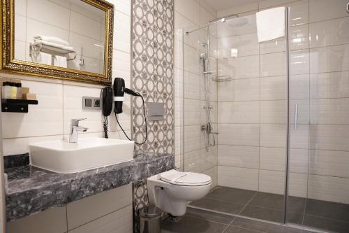 a bathroom with a toilet and a sink and a shower at Resun Hotel in Ankara