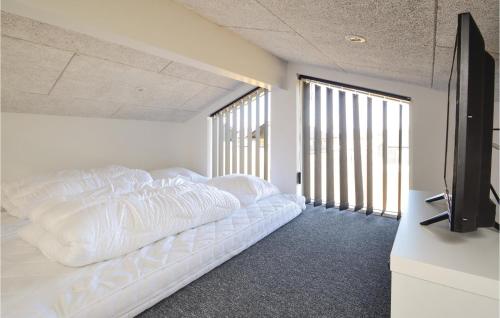 ハザスレウにあるGorgeous Home In Haderslev With Saunaのベッドルーム(白いベッド1台、薄型テレビ付)