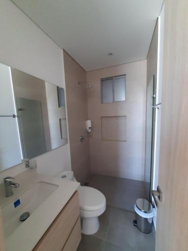 a bathroom with a white toilet and a sink at El Samario Cumbia Host-Playa Salguero- Santa Marta in Gaira