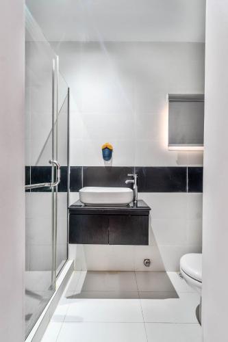 a white bathroom with a sink and a toilet at Gorgeous Short-let Apartment Lekki in Lekki