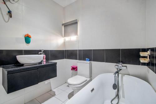a bathroom with a tub and a toilet and a sink at Gorgeous Short-let Apartment Lekki in Lekki