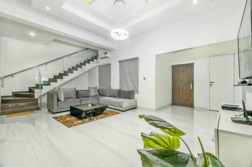 a living room with a couch and a staircase at Gorgeous Short-let Apartment Lekki in Lekki