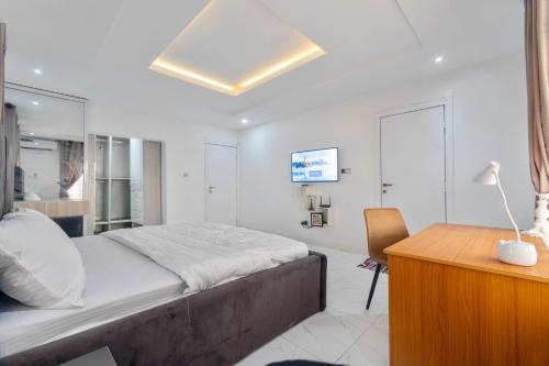 a bedroom with a large bed and a desk at Gorgeous Short-let Apartment Lekki in Lekki